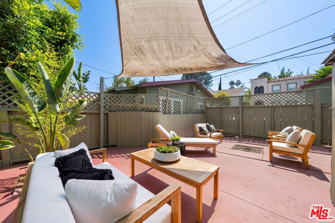 a view of a patio with couches table and chairs and potted plants