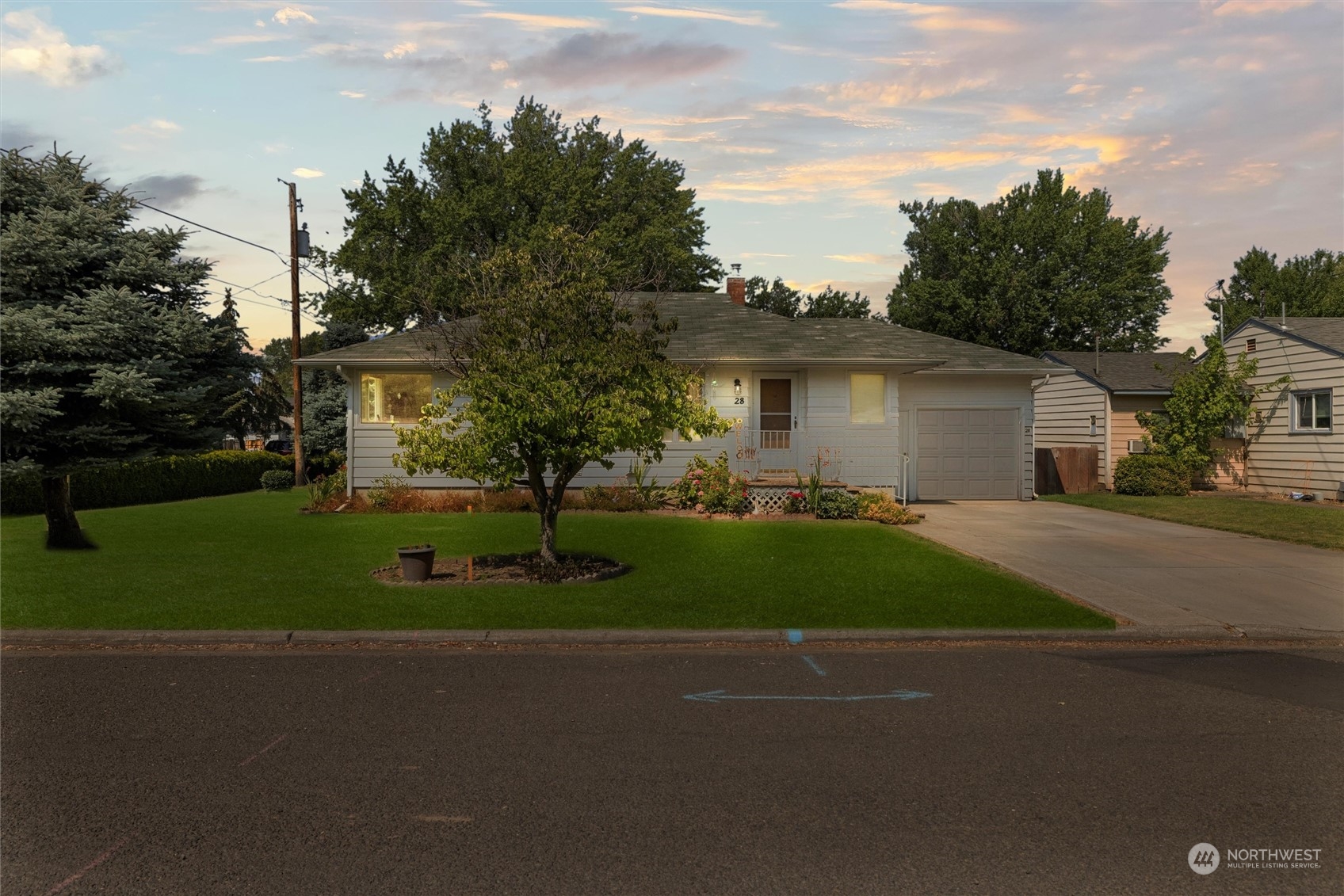 a front view of a house with a garden and trees