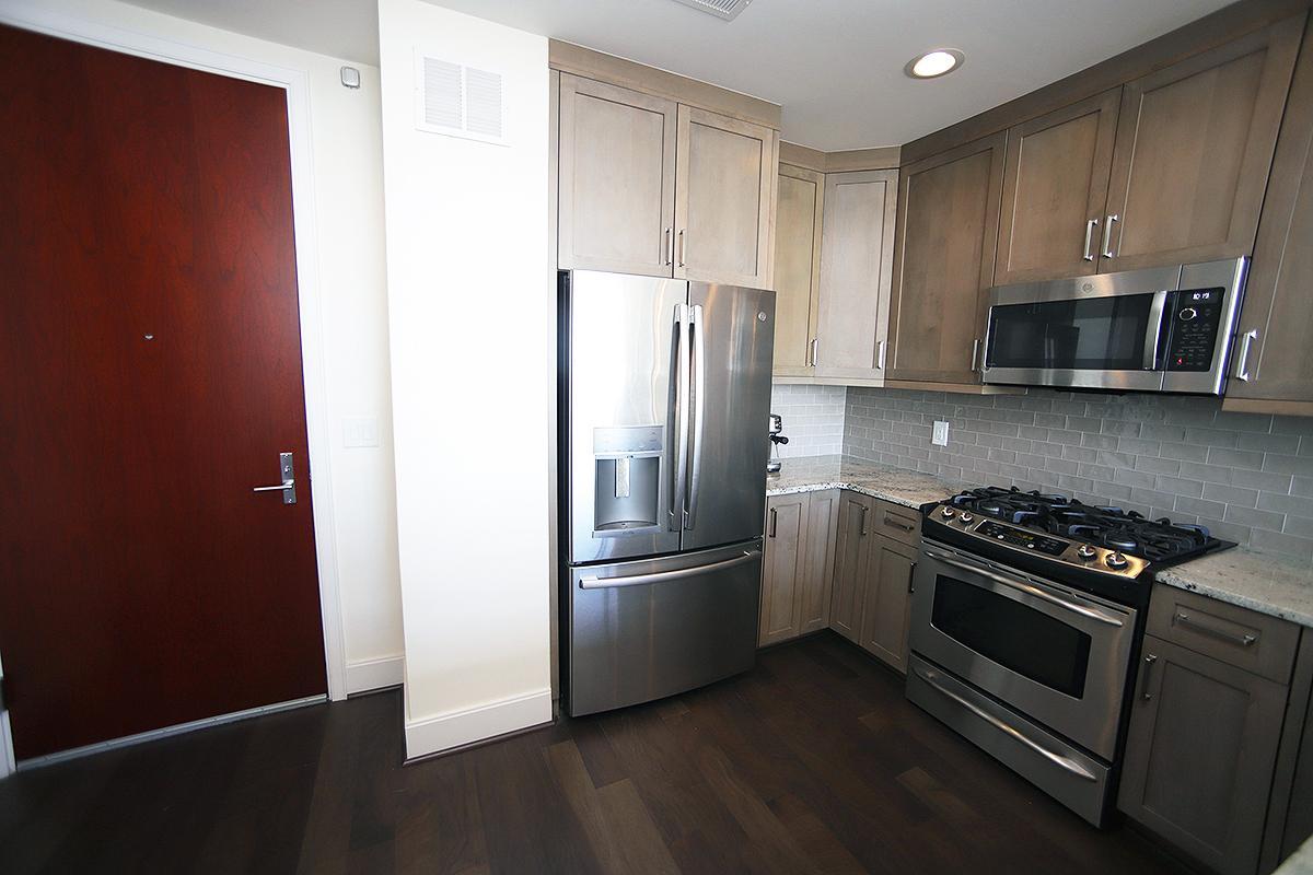 a kitchen with granite countertop wooden cabinets and stainless steel appliances