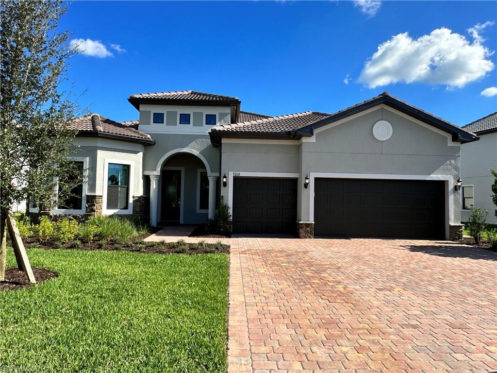 Mediterranean / spanish house featuring a garage and a front lawn