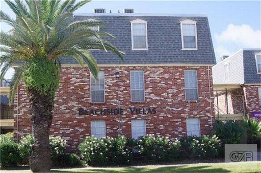 front view of a brick house with a yard