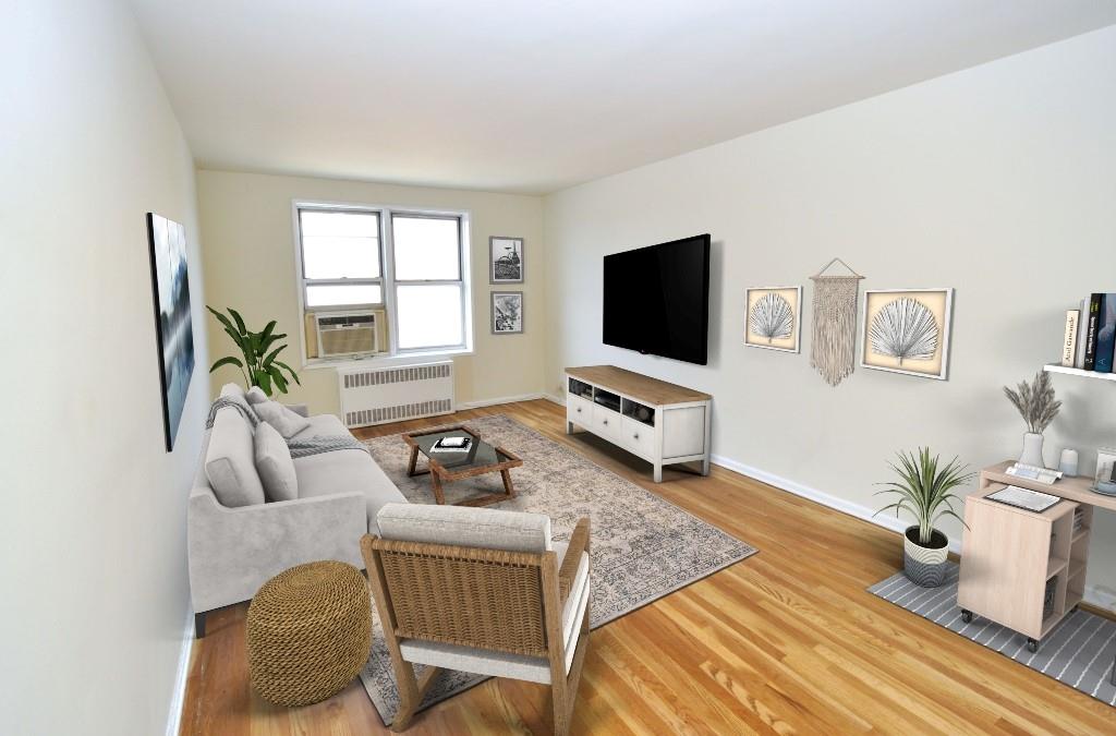 Sunny living room opens to the dining foyer and has refinished hardwood floors and has been freshly painted.  The living room is 18'-6" x 11'-1". photo visually staged