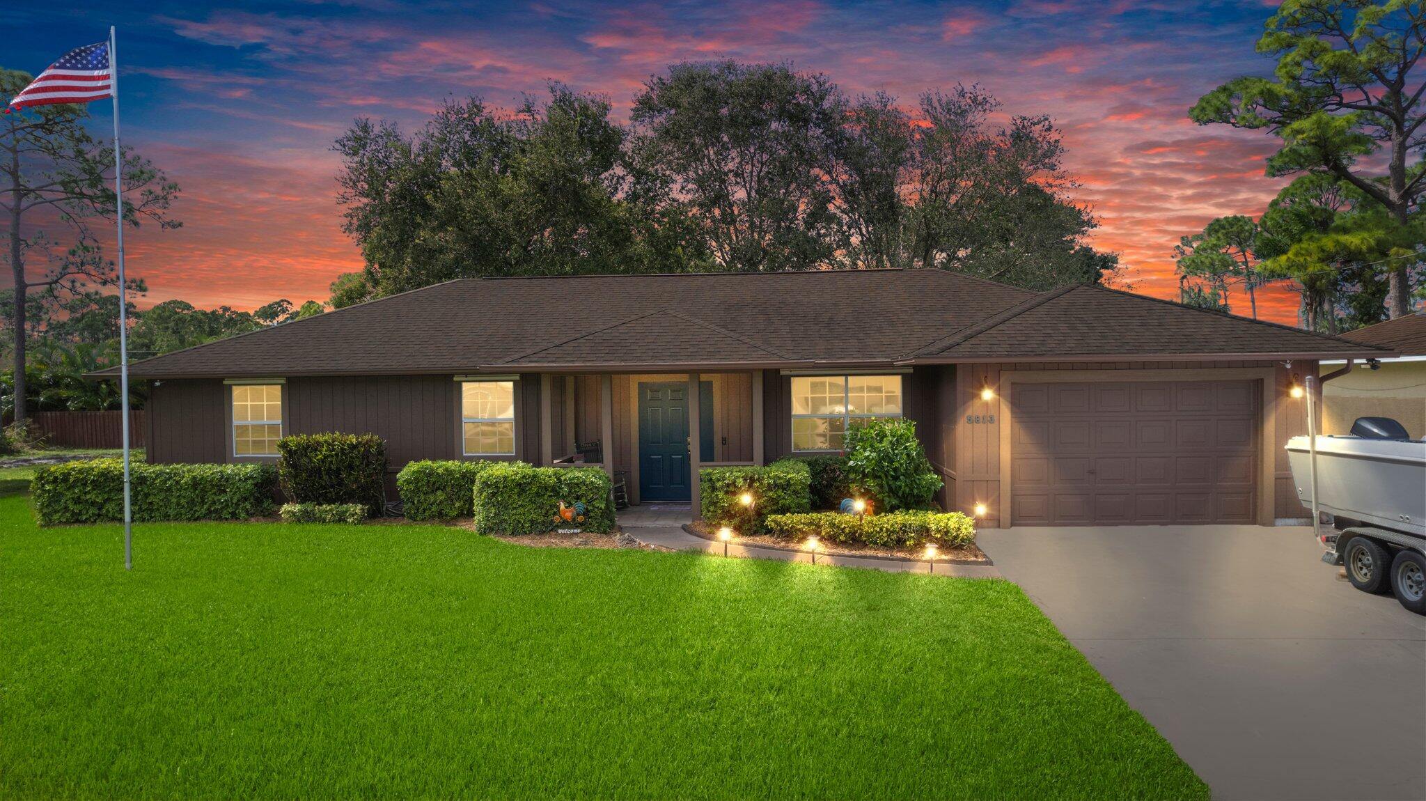 a front view of a house with yard and green space