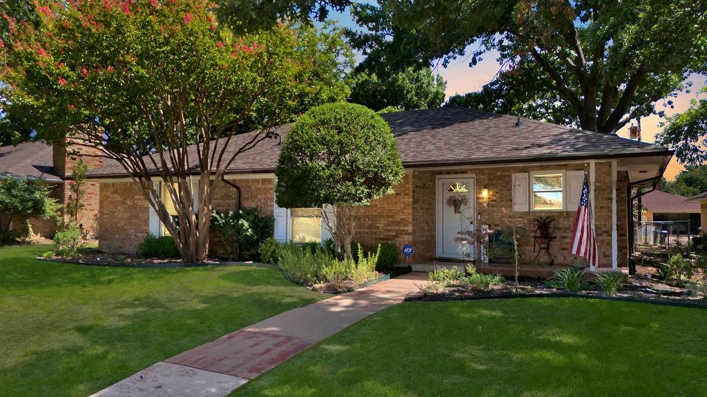 a front view of a house with a garden and plants