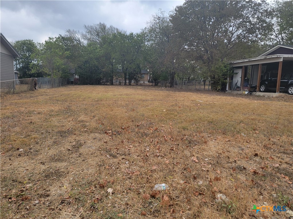 a view of house with yard and trees in the background