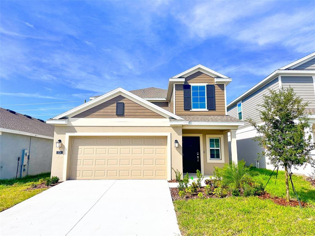 a front view of a house with a yard and garage