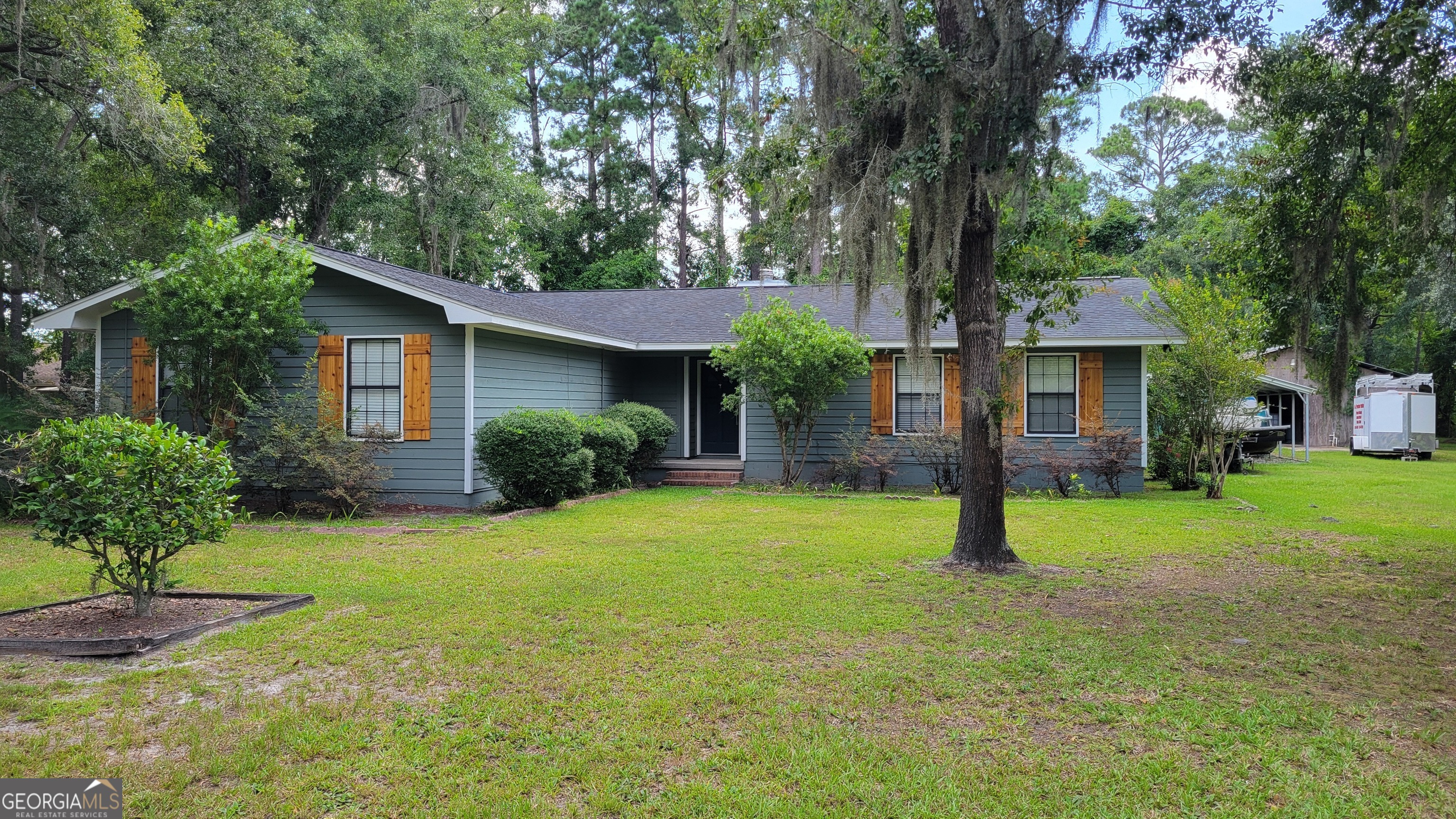 a view of a house with a yard and potted plants