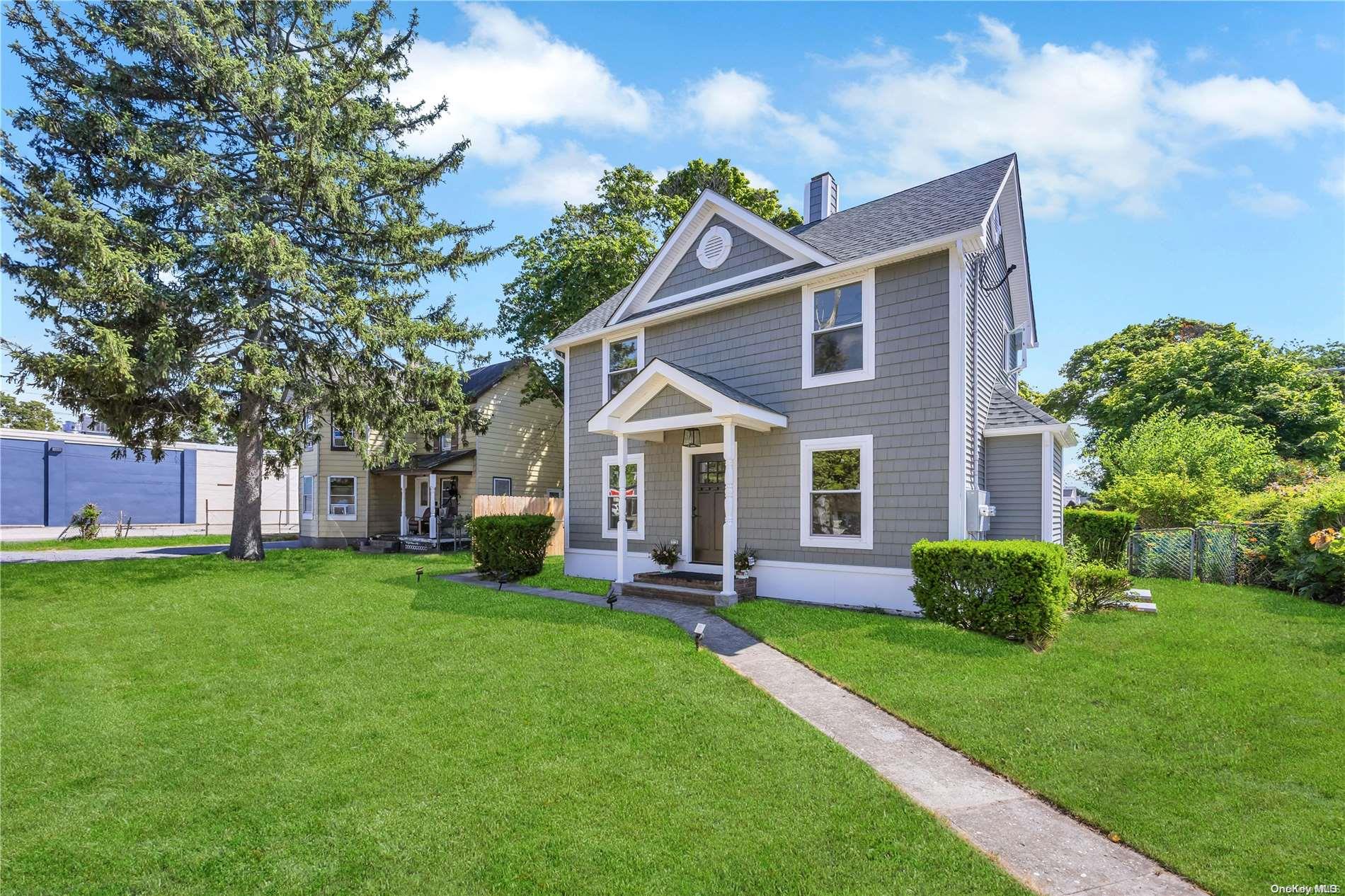 a front view of a house with a yard and trees