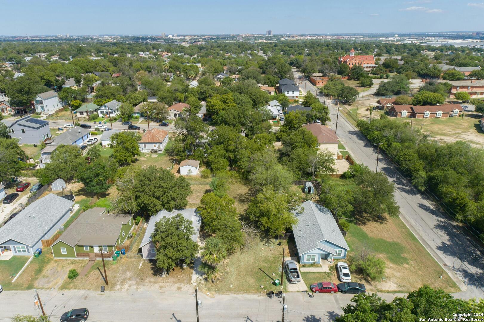 an aerial view of residential houses with outdoor space and trees