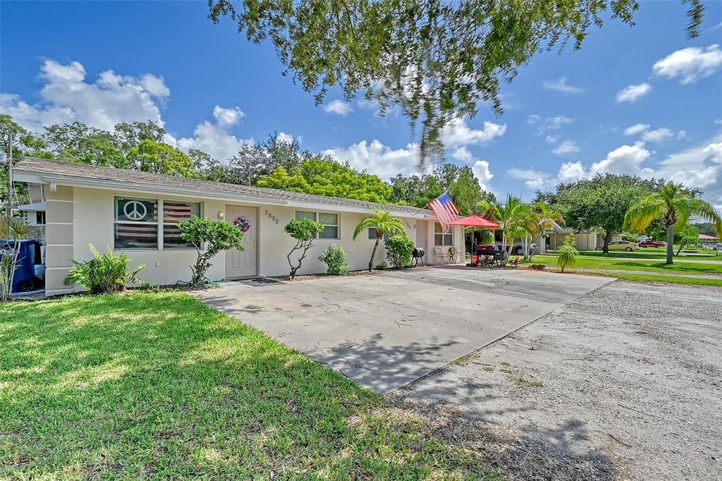 a view of a house with backyard and a tree