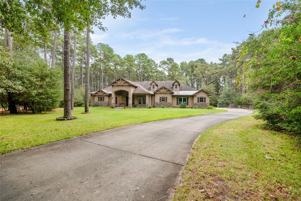 a view of a house with a big yard and large trees