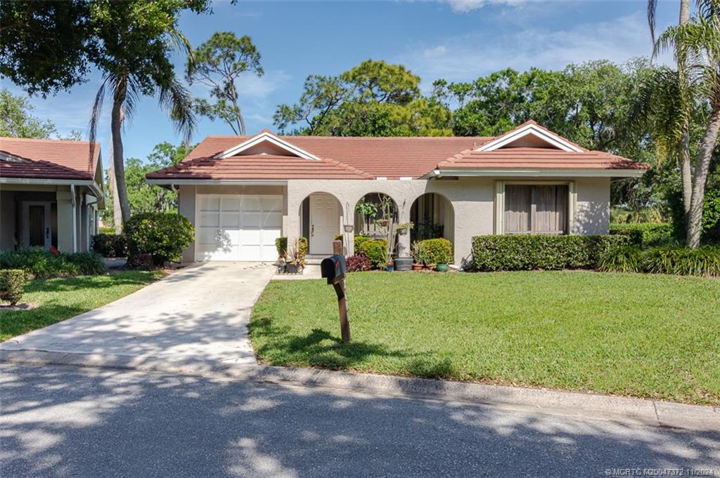 a front view of a house with a yard and a garage