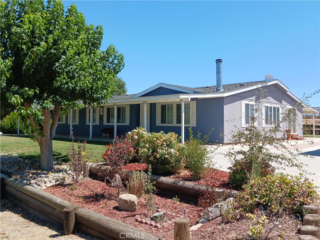 a front view of a house with a yard and potted plants