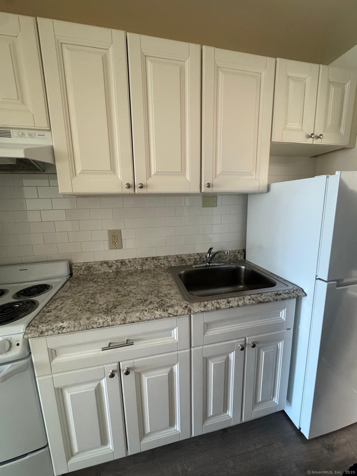 a kitchen with stainless steel appliances granite countertop a sink stove and cabinets