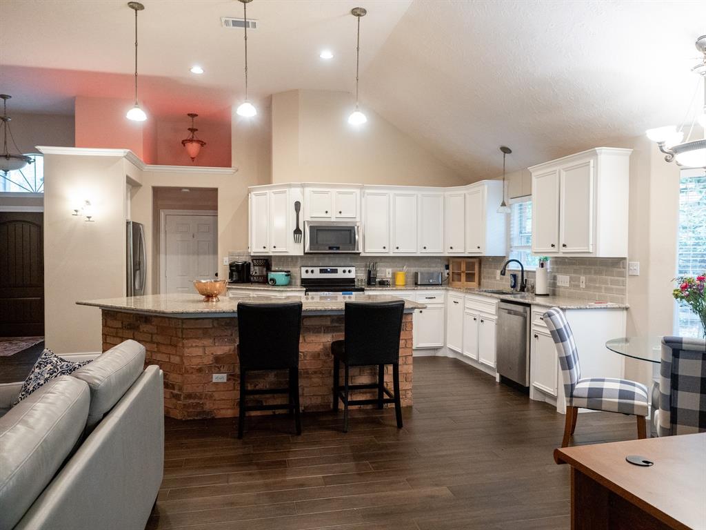 a kitchen with a dining table chairs stainless steel appliances and cabinets