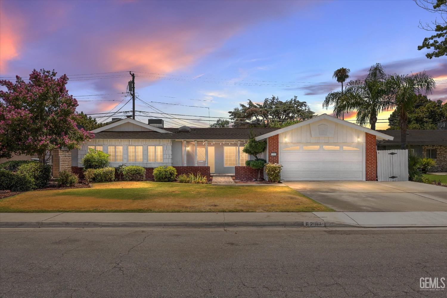 a front view of a house with a yard and a garage