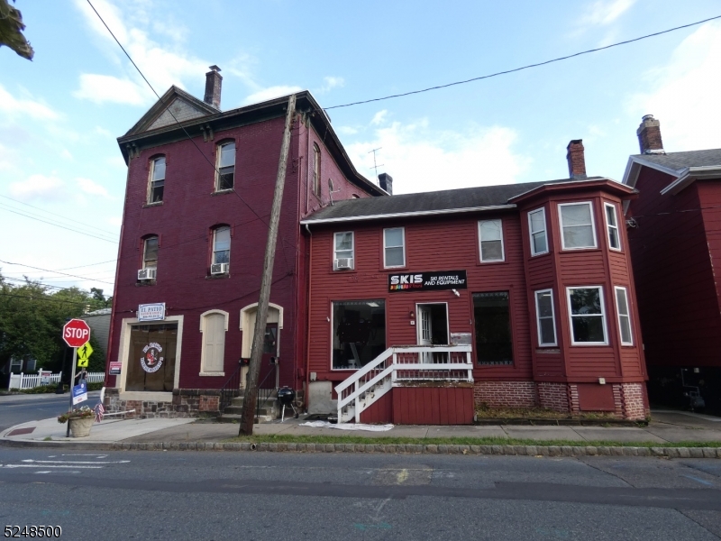 a view of a brick house with many windows and a yard