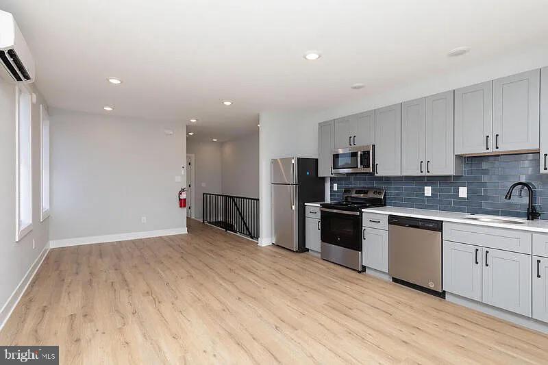 a kitchen with stainless steel appliances granite countertop a stove a sink and a refrigerator