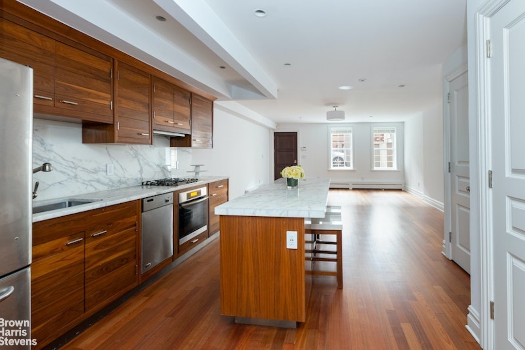 a kitchen with wooden floors and wooden cabinets