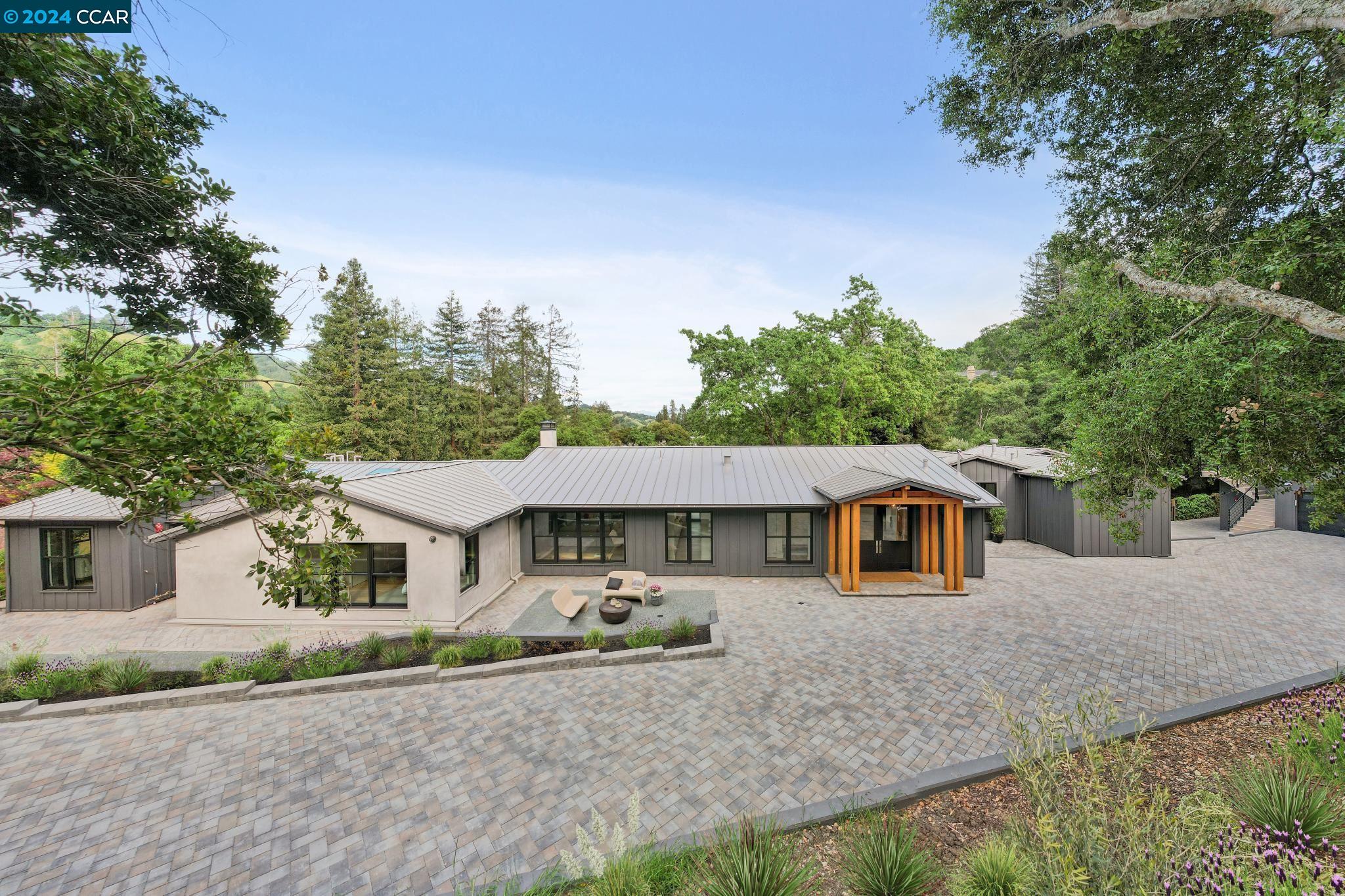 a front view of a house with a yard and trees