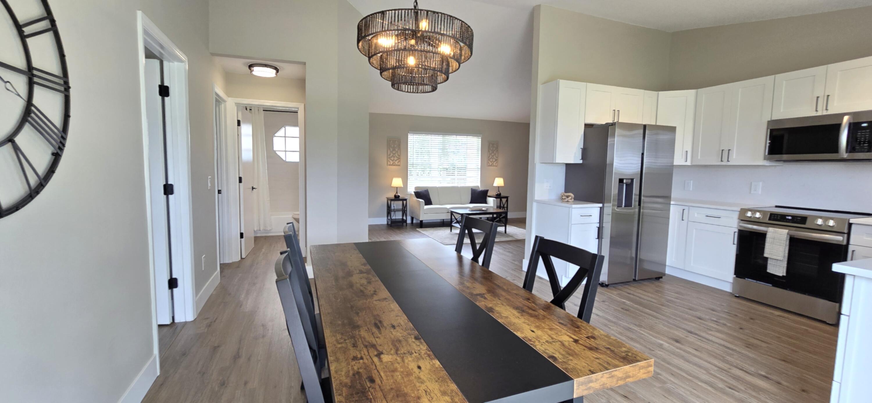 a view of a dining room with furniture a chandelier and wooden floor