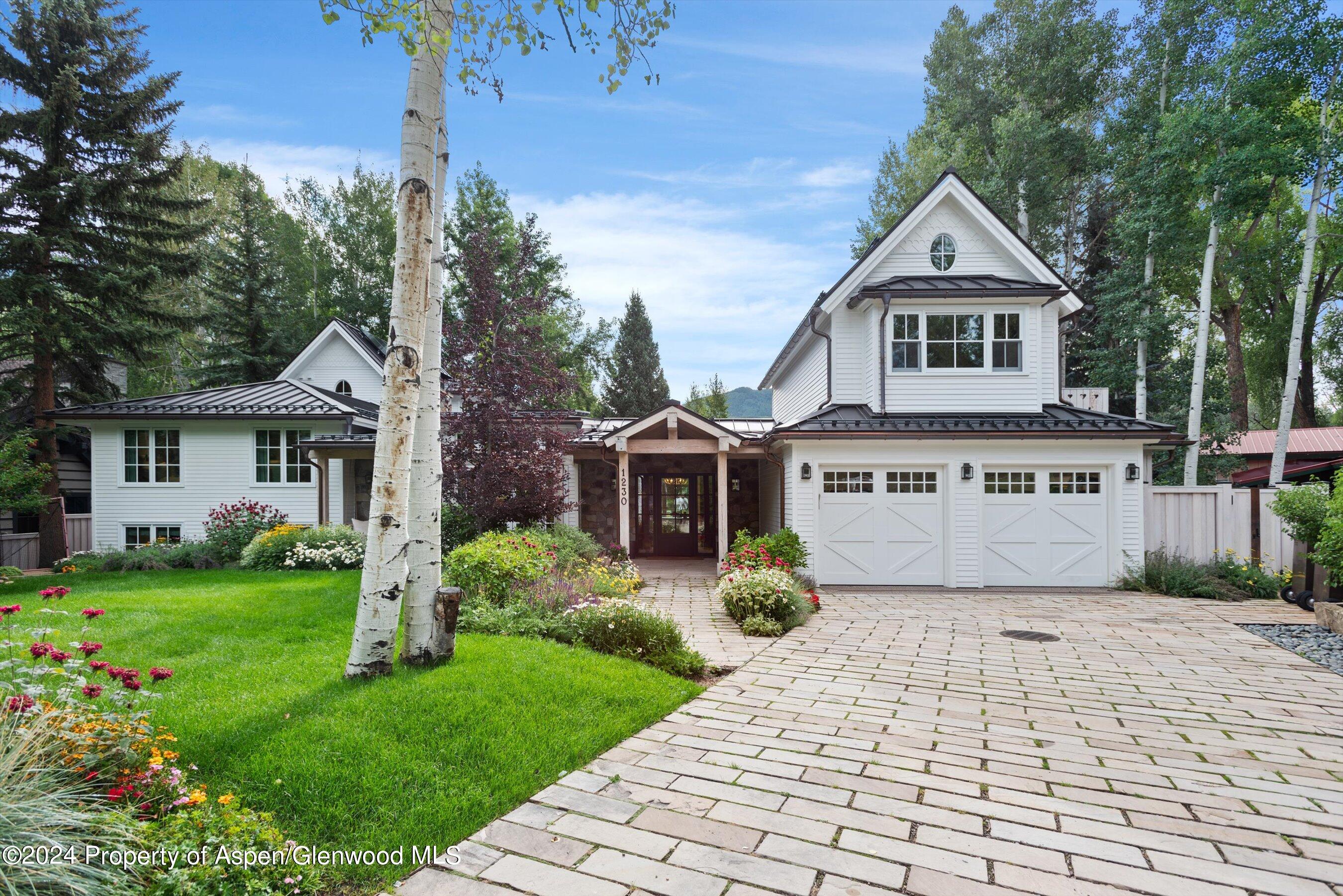 a front view of a house with a yard and trees