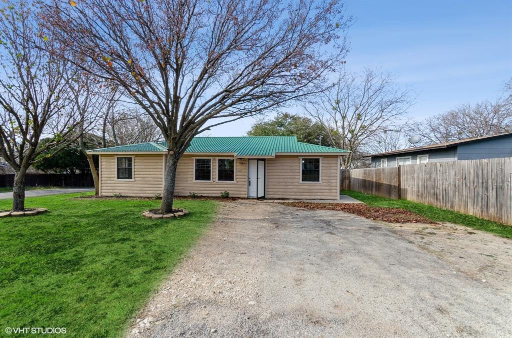 a view of a yard with a house and a large tree