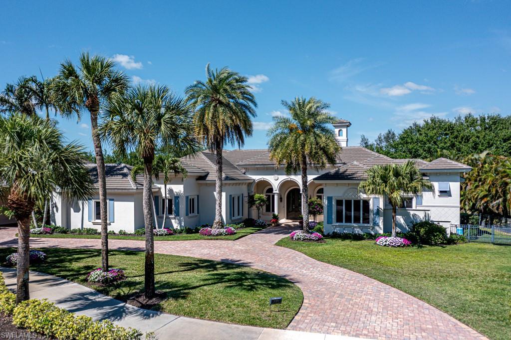 a front view of a house with palm trees