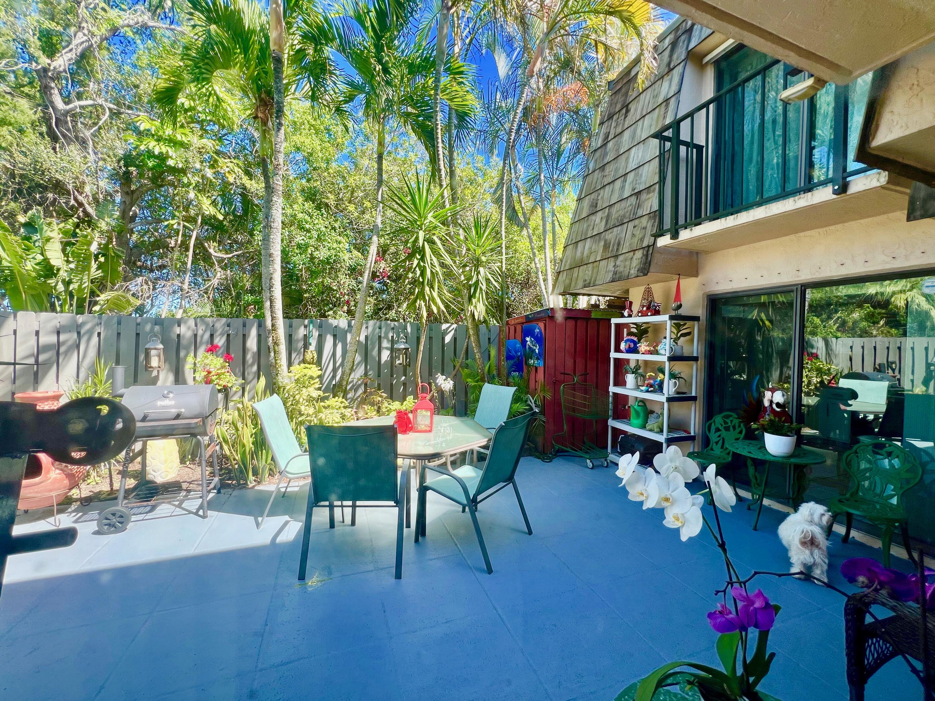 a view of a patio with table and chairs potted plants and large tree