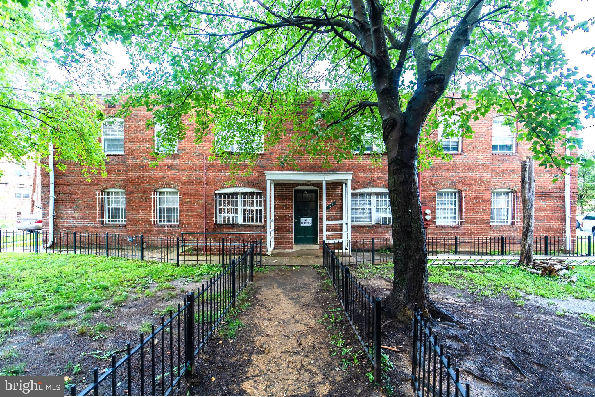 a front view of a house with a yard and an tree