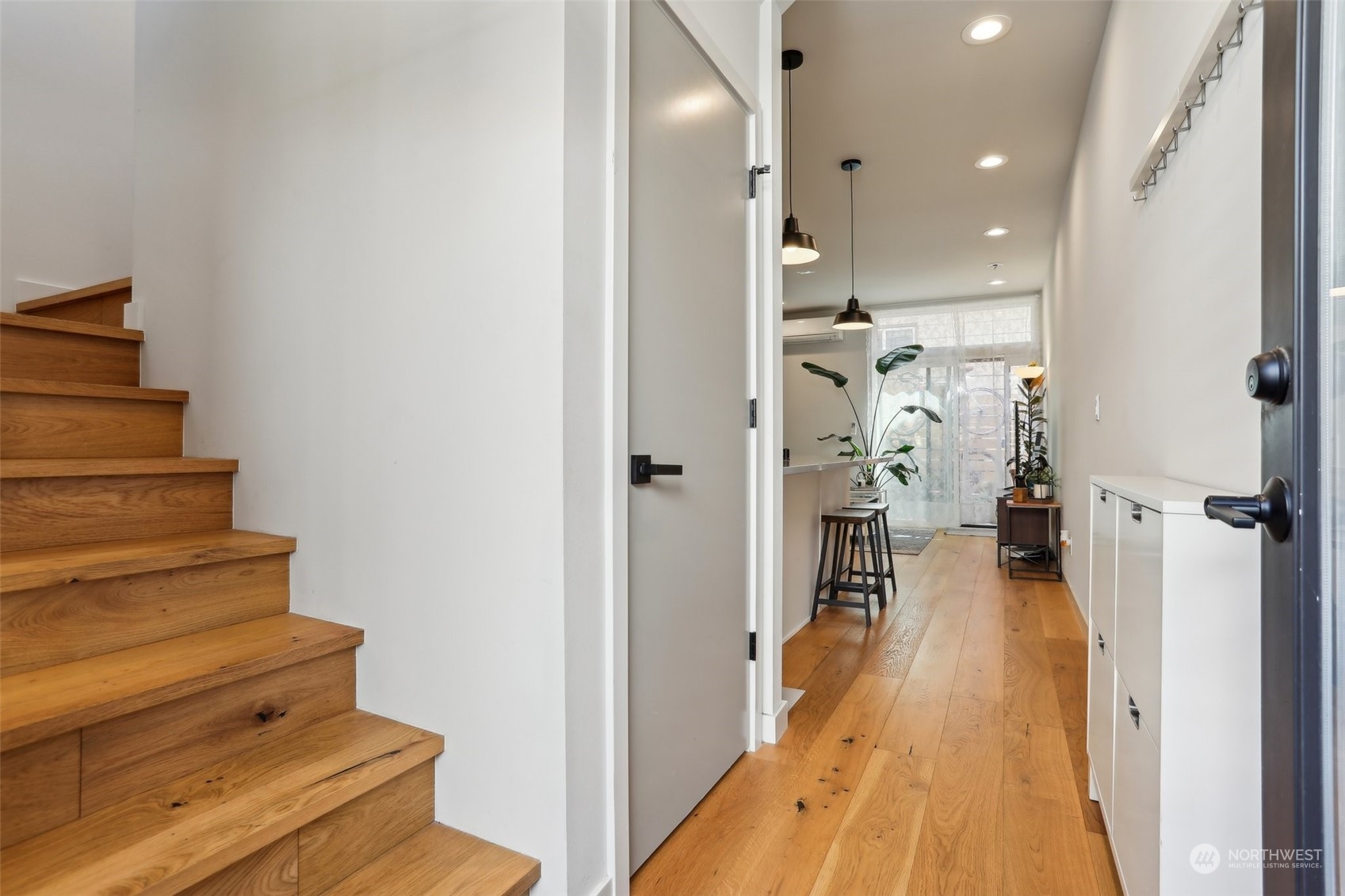 a view of a hallway with wooden floor and staircase