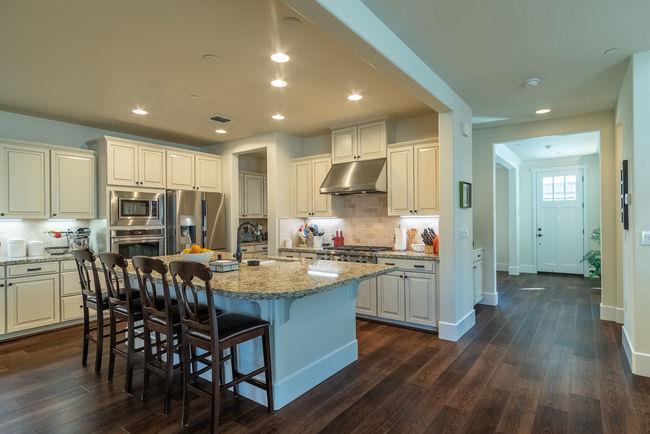 a kitchen with kitchen island granite countertop wooden floors and wooden cabinets