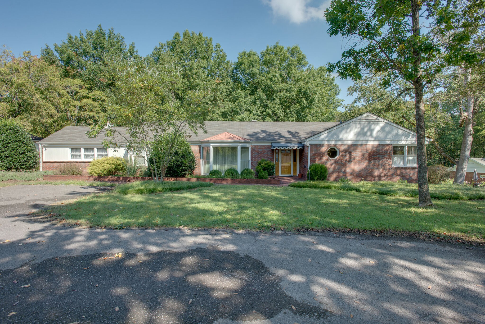 a front view of a house with a yard and trees