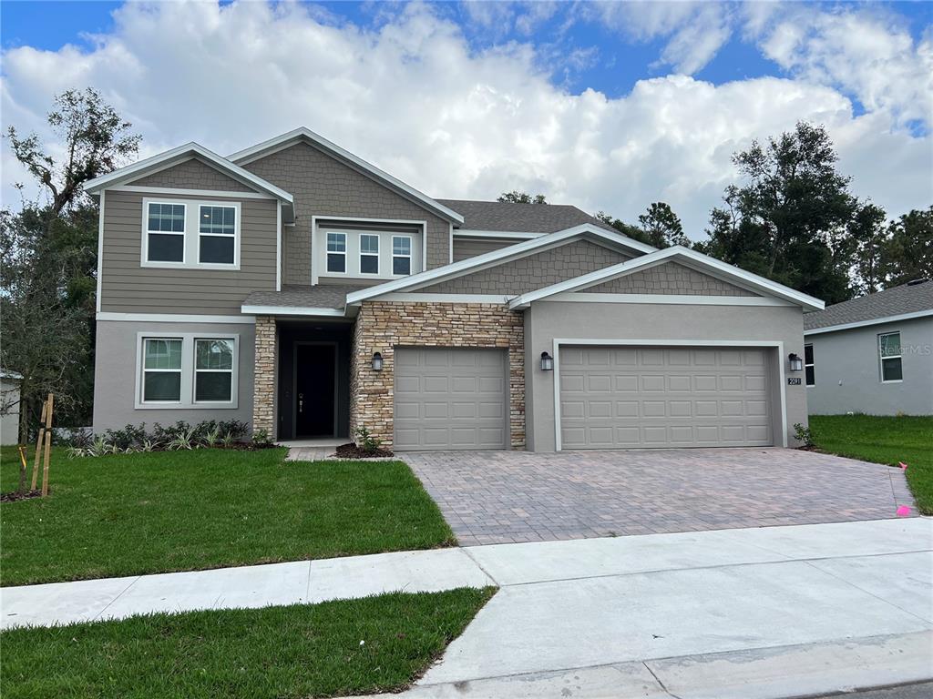 a front view of a house with a yard and garage