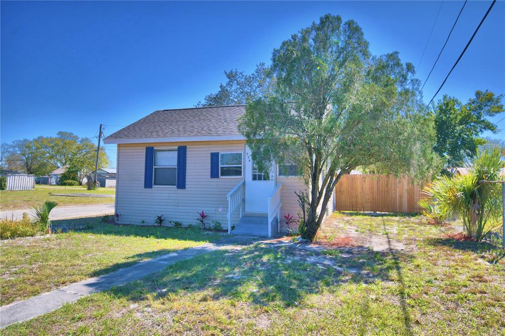 a view of a house with backyard and tree