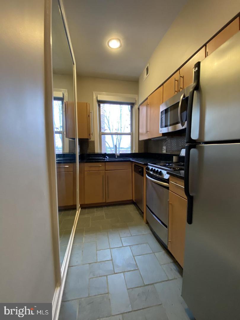 a kitchen with stainless steel appliances granite countertop a refrigerator and a sink