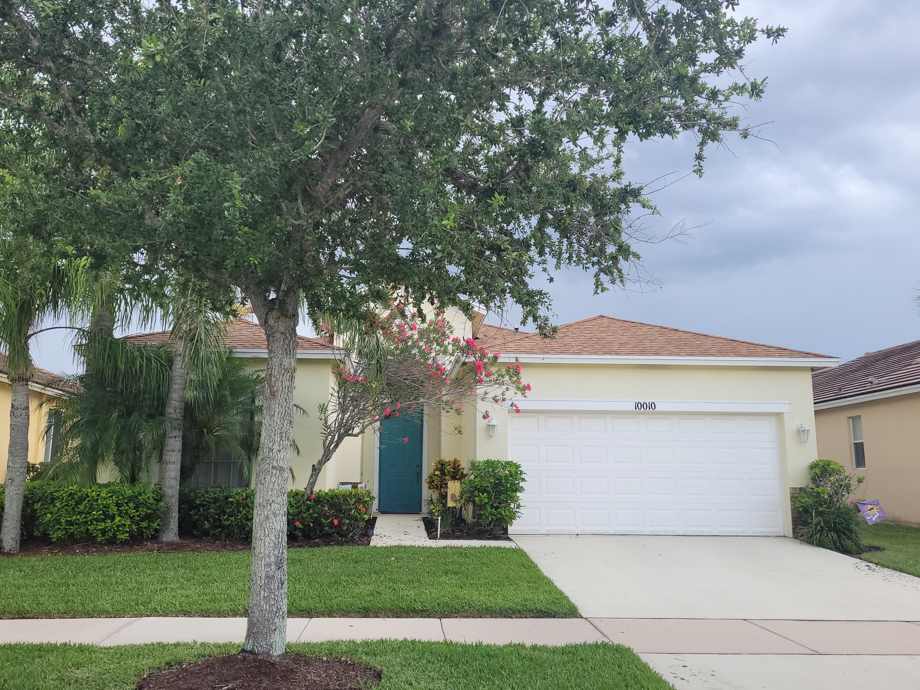 a front view of a house with a yard and trees