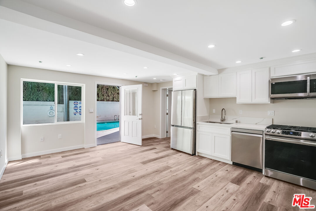 a kitchen with stainless steel appliances granite countertop a refrigerator and a stove top oven