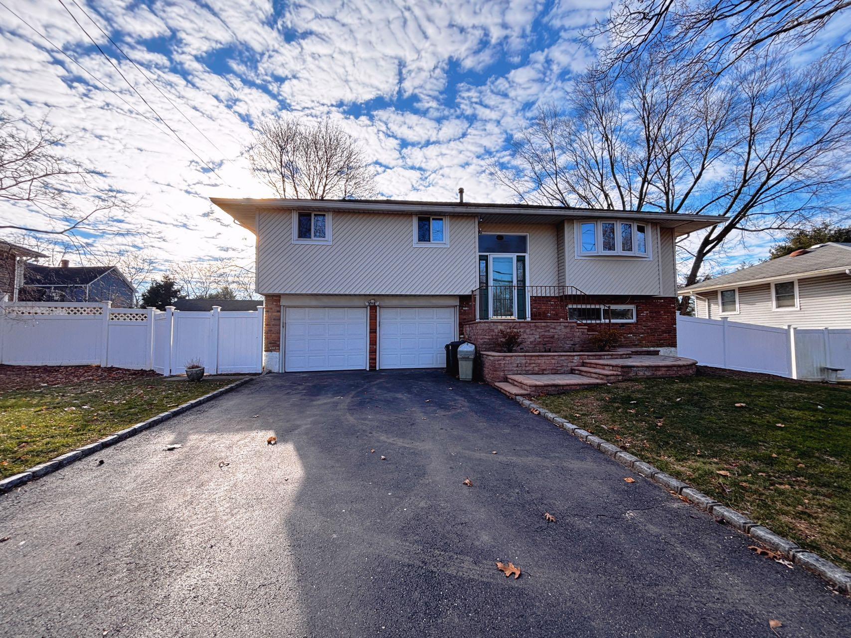 Bi-level home with a garage and a front lawn