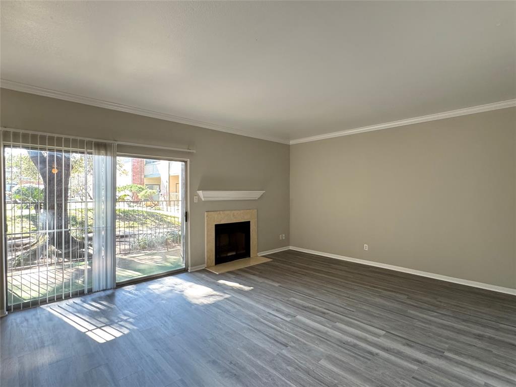 a view of empty room with wooden floor and fireplace