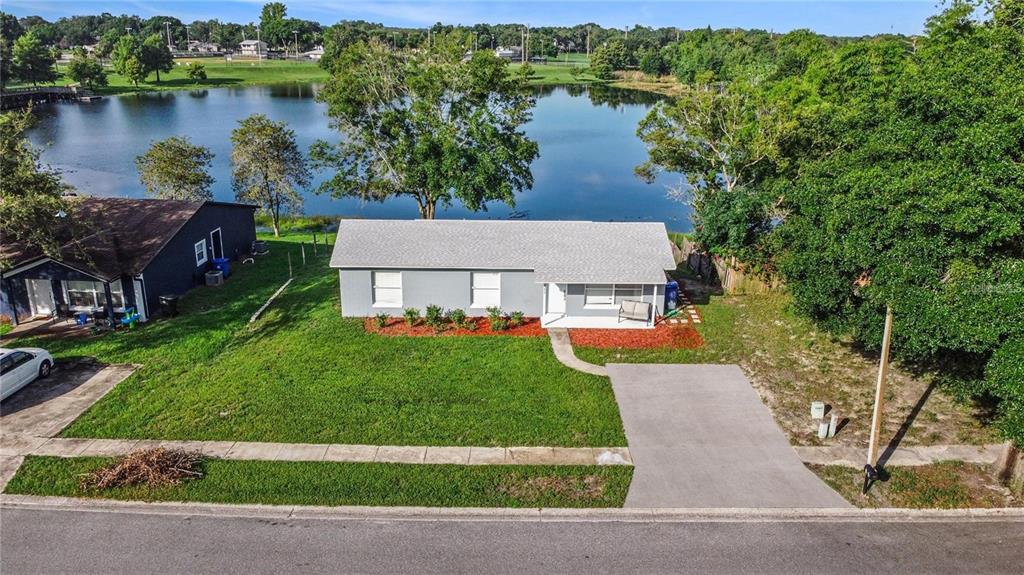 an aerial view of a house with garden space and lake view