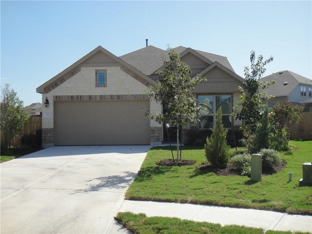 a front view of house with a garden