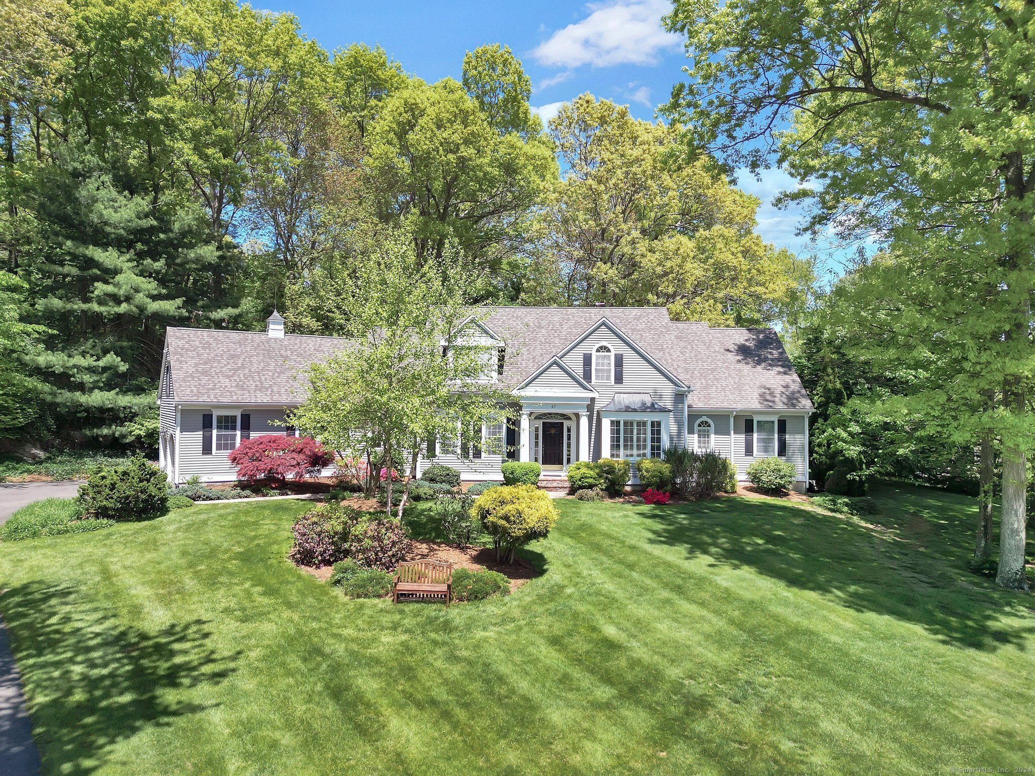 a front view of a house with a yard and trees