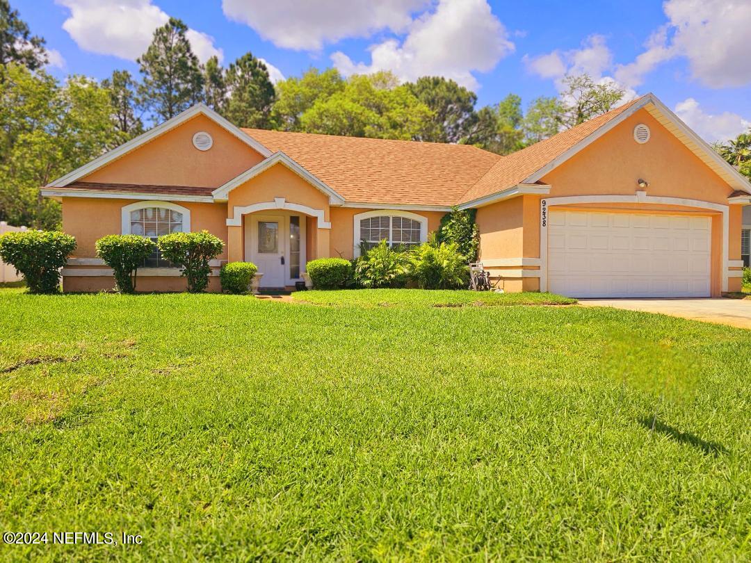 a front view of a house with yard and garage