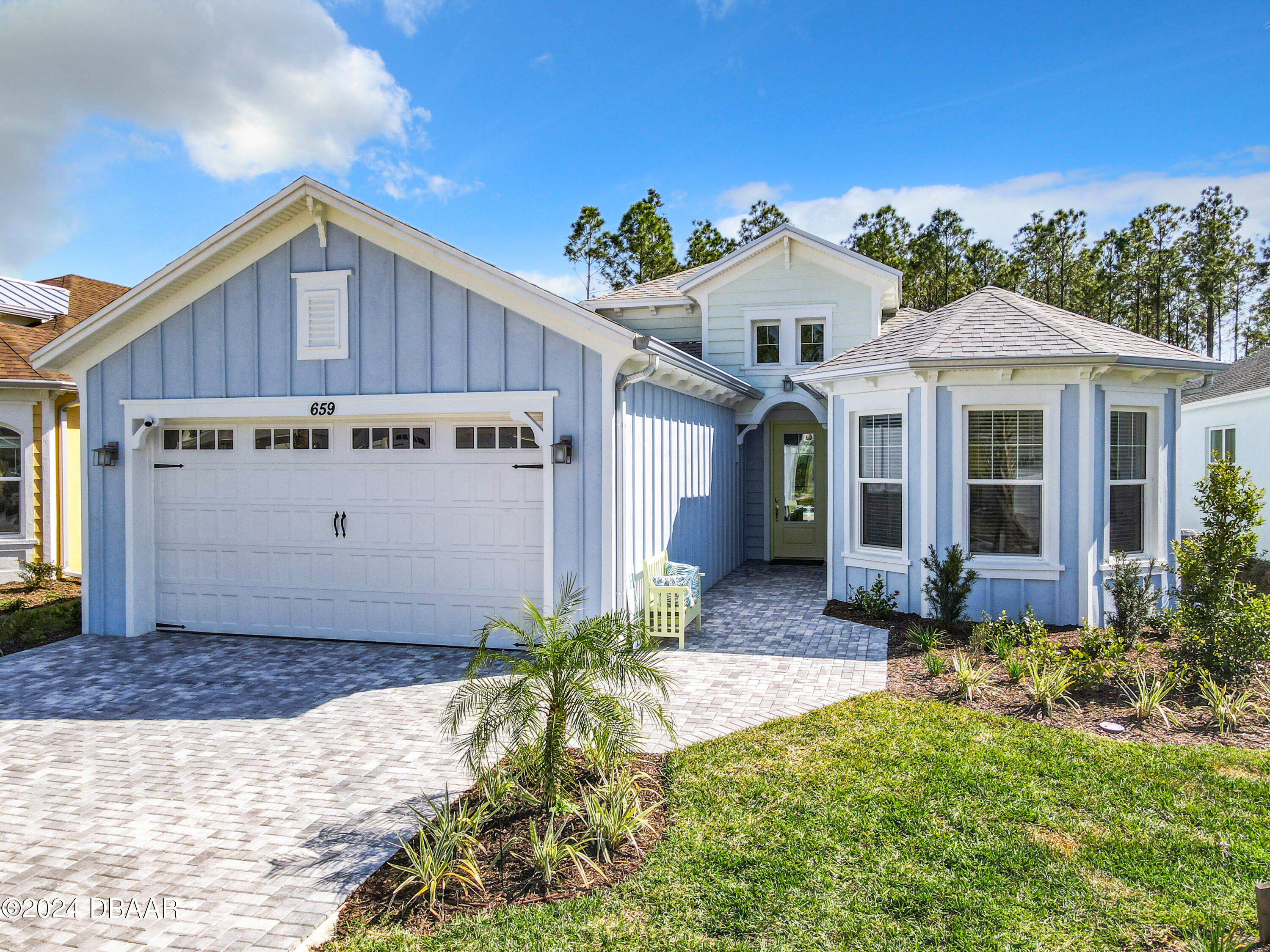 a front view of a house with a yard outdoor seating and garage