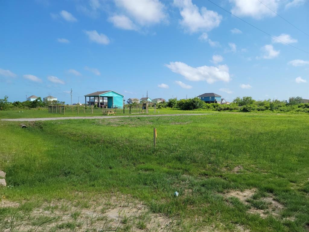 a big yard with lots of green space and trees in the background