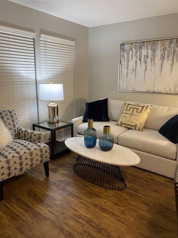 a living room with furniture and a wooden floor