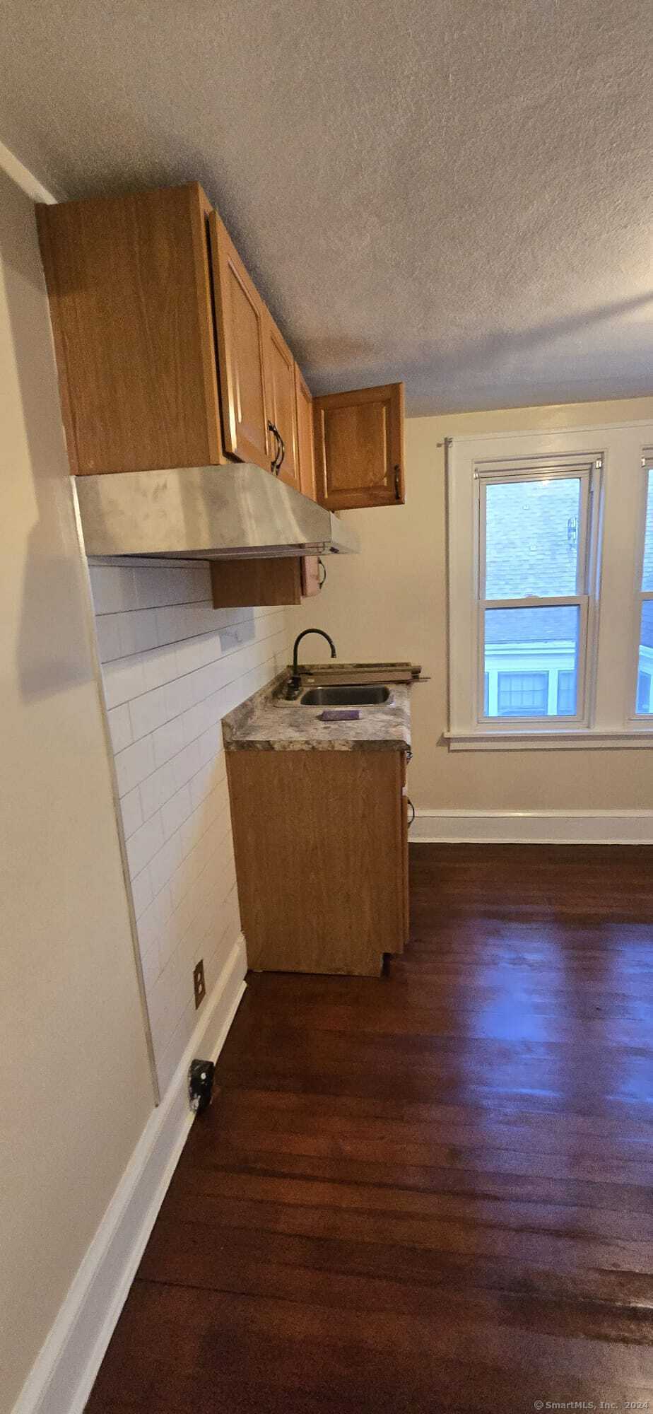 a view of a room with wooden floor and cabinet