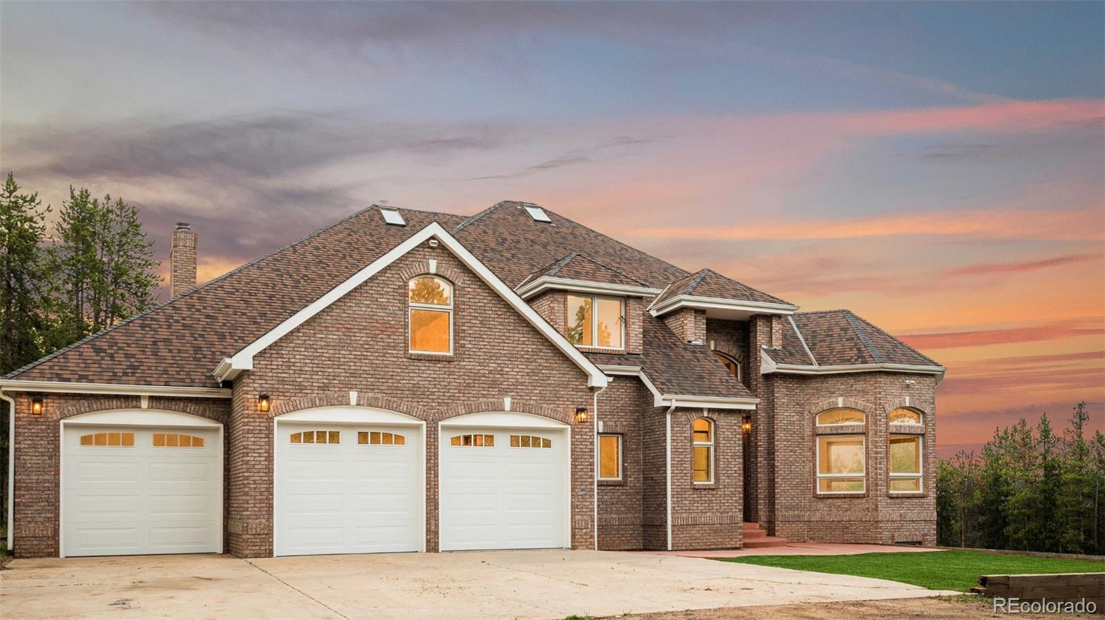 a view of a big house with a big yard and large windows