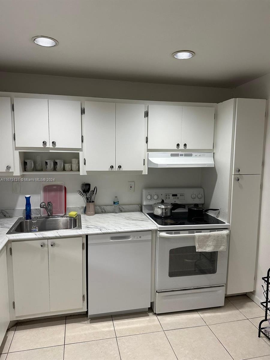 a kitchen with a stove top oven and cabinets